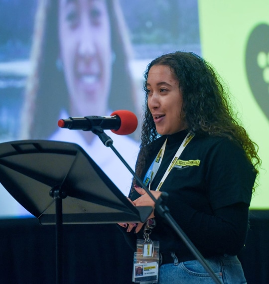 An image of a young woman speaking on stage at an event representing Black Voices Cornwall.